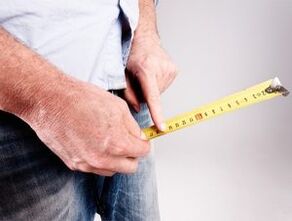 a man measures the length of the penis before augmentation with soda